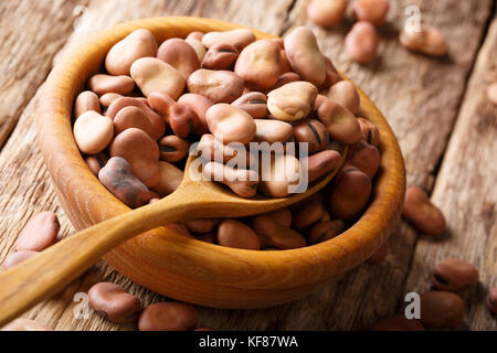 Dried broad beans close-up in a wooden bowl on the table. horizontal Stock Photo