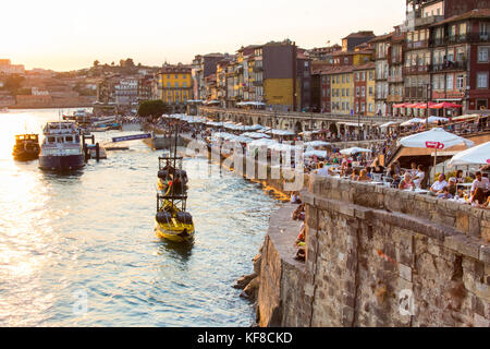 Tourists and locals enjoying the river, drinks and the sunset, Porto, Portugal Stock Photo