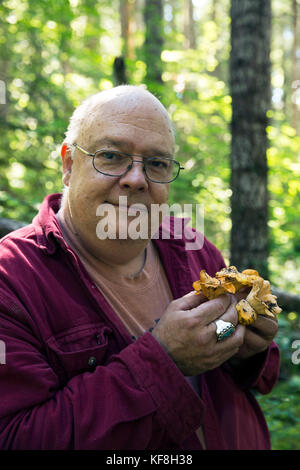 USA, Oregon, Willamette Valley, portraits of chef and mushroom hunter Jack Czarnecki holding Chanterelle mushroooms in the Coastal Range Mountains, Ca Stock Photo