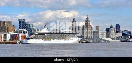 Regent Seven Seas Explorer cruise ship liner docked at the Liverpool waterfront cruise terminal with the famous iconic Royal Liver Building beyond Stock Photo