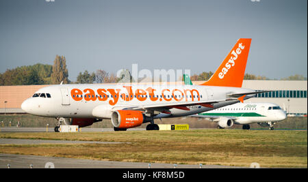 Milan Linate, Italy - Oct 25, 2017: An Easyjet Airbus A320-200 taxiing at Milan's Linate Airport, with an Alitalia airplane just behind Stock Photo