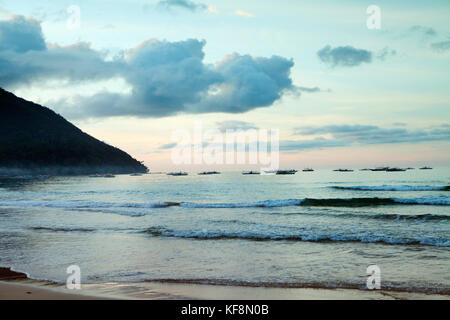 PHILIPPINES, Palawan, Sabang, fishing boats are anchored off of the main beach in the town of Sabang Stock Photo