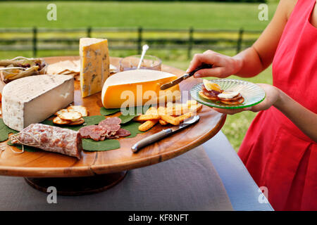 USA, Tennessee, Nashville, Iroquois Steeplechase, young woman serving cheese from a cheese tray Stock Photo