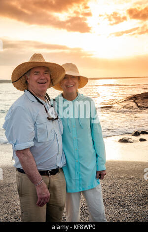 GALAPAGOS ISLANDS, ECUADOR, individuals hang out on the beach and watch the sunset from Fernandina Island Stock Photo