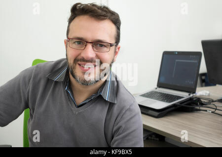 happy young business man, software developer, computer technician working in modern office of a start up Stock Photo