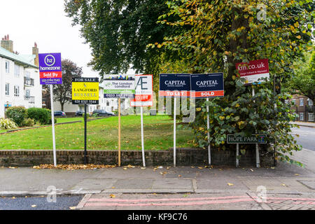 Multiple Sold, For Sale and To Let estate agents' boards outside a block of residential flats in south London. Stock Photo