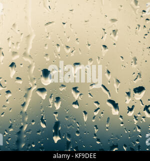 A close-up shot of raindrops flowing down a window. Stock Photo