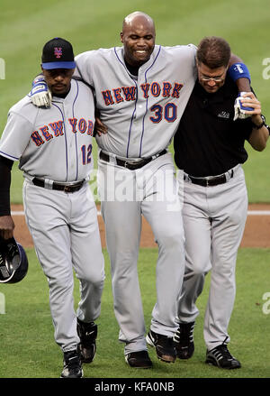 New York Mets' Cliff Floyd, center, grimaces while walking off the field with the help of manager Willie Randolph, left, and a trainer in the second inning of a baseball game against the Los Angeles Dodgers in Los Angeles on Tuesday, June 6, 2006. Floyd injured himself sliding into third base. Photo by Francis Specker Stock Photo