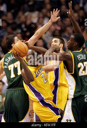 Los Angeles Lakers' Aaron McKie (2) looks to pass against the Seattle Supersonics' defense of Vladimir Radmanovic of Bosnia-Hercegovina (77) and Johan Petro (27) of France in the first half in Los Angeles on Thursday, Nov. 24, 2005. Photo by Francis Specker Stock Photo