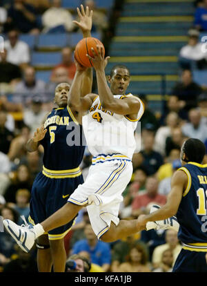 UCLA's Aaron Afflalo, center, looks to pass the ball while guarded by Michigan's Dion Harris, left, and Ashtyn Bell, right, during the first half in Los Angeles on Saturday, Dec. 18, 2004.  Photo by Francis Specker Stock Photo