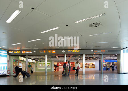 passengers walking in the terminal with sign for gates A1-A34, B11-B21, C1-C49, way out to Roma and baggage claim in English and Italian languages Stock Photo