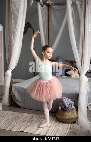 Cute little ballerina in pink ballet costume and pointe