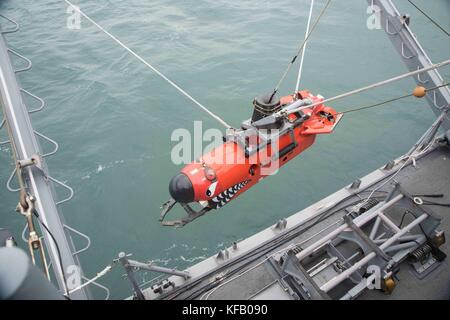 U.S. Navy sailors lower a mine neutralization vehicle into the water from the U.S. Navy Avenger-class mine countermeasures ship USS Chief during the Multinational Mine Warfare Exercise October 17, 2017 in Busan, Republic of Korea.   (photo by Jordan Crouch via Planetpix) Stock Photo