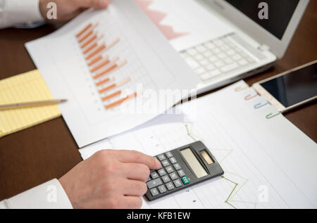 Business man is checking with a calculator. Business finance, tax, accounting, statistics and analytic research concept Stock Photo