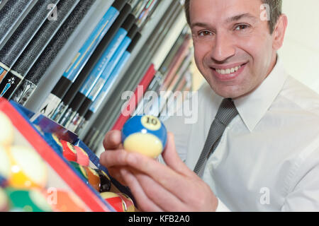 handsome businessman holding billiard ball Stock Photo