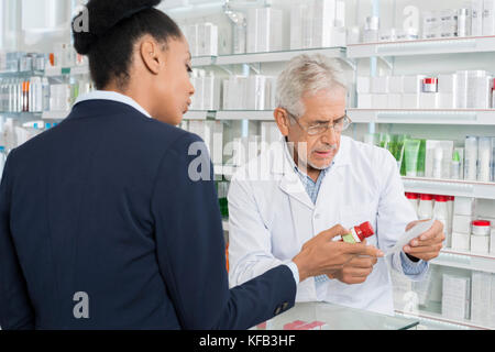 Chemist And Businesswoman With Medicine And Prescription Paper Stock Photo