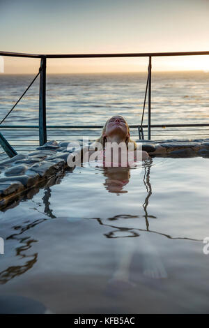 USA, California, Big Sur, Esalen, a woman sits in the Baths and relaxes at the Esalen Institute Stock Photo