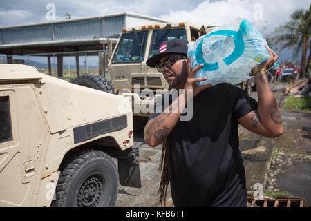 Salsa and timba musician Pirulo helps U.S. National Guard soldiers deliver water and emergency supplies during relief efforts in the aftermath of Hurricane Maria October 17, 2017 in Yabucoa, Puerto Rico.                                                                                                                                                                                                                                                          (photo by Andrea Booher via Planetpix) Stock Photo