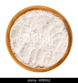 Whole wheat flour in wooden bowl. Whole-wheat flour, also wholemeal flour. White powdery substance and basic food ingredient, used in baking. Photo. Stock Photo