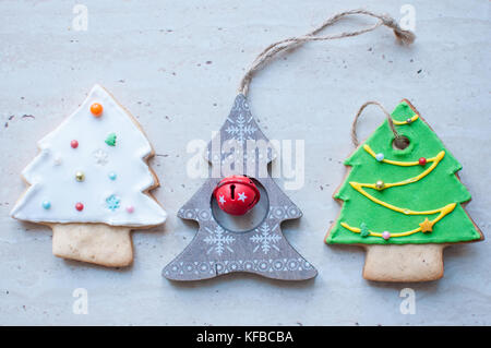 Three Christmas toys in the shape of Christmas tree. The green and white trees are gingerbread cookies, the gray tree is a wooden christmas toy. Stock Photo