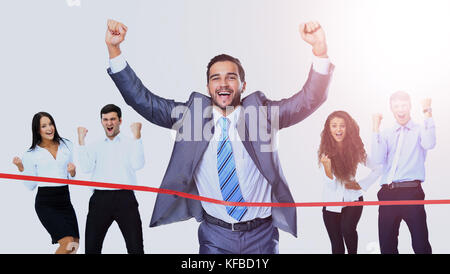 Happy businessman running through finishing line Stock Photo