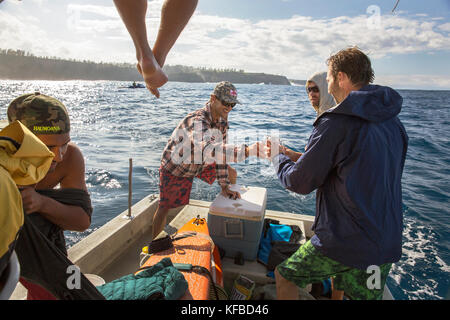 USA, HAWAII, Maui, Jaws, big wave surfers enjoying a few beers on the boat at Peahi on the Northshore Stock Photo