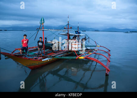 PHILIPPINES, Palawan, Puerto Princesa, fishermen stand on their boat in the City Port Area Stock Photo