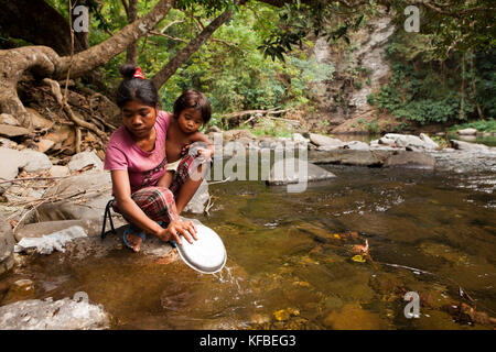 PHILIPPINES, Palawan, Barangay region, young Batak mother Diovina and daughter Lenilyn wash dishes in the stream in Kalakwasan Village Stock Photo