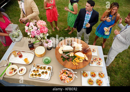 USA, Tennessee, Nashville, Iroquois Steeplechase, friends stand around a buffet table eating and drinking Stock Photo