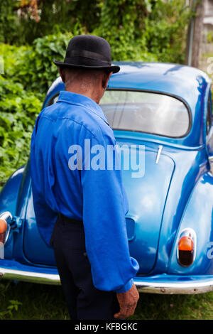 JAMAICA, Port Antonio. Joseph 'Powder' Bennett of the Mento band, The Jolly Boys standing in front of a vintage blue car. Stock Photo