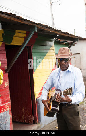 JAMAICA, Port Antonio. Albert Minott of the Mento band, The Jolly Boys playing guitar at the Willow Wind Bar. Stock Photo