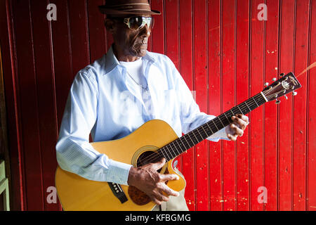 JAMAICA, Port Antonio. Albert Minott of the Mento band, The Jolly Boys playing guitar at the Willow Wind Bar. Stock Photo