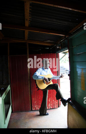 JAMAICA, Port Antonio. Albert Minott of the Mento band, The Jolly Boys playing guitar at the Willow Wind Bar. Stock Photo