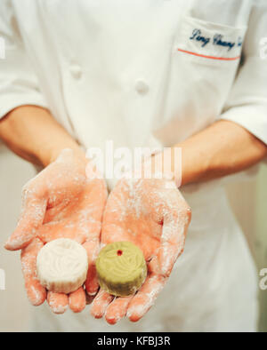SINGAPORE, Ritz Carlton Hotel, mid section of chef holding moon cakes. Stock Photo