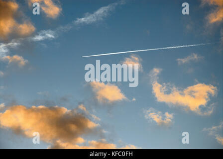 Chesil Beach, UK.  27th October 2017. A passenger jet's con-trail cuts through coral-coloured clouds over Chesil Beach, at sunset Credit: stuart fretwell/Ģ����ý Live News Stock Photo