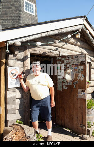 USA, Alaska, Homer, the Salty Dawg Saloon, an old fisherman smiles in the entrance to the bar, Land's End, the Homer Spit Stock Photo