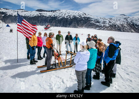 USA, Alaska, Juneau, the groups huddles together prior to going dog sledding, Helicopter Dogsled Tour flies you over the Taku Glacier to the HeliMush  Stock Photo