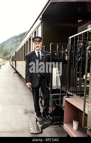 USA, Alaska, Sitka, one of the train conductors aboard the White Pass & Yukon Route Railroad from the town of Sitka up and into Canada Stock Photo