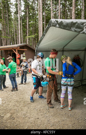 USA Alaska, Sitka, participants prepare for their 4-hour adventure where they will zip past massive spruce, cedars and glacially fed waterfalls, Grizz Stock Photo