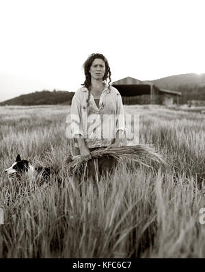 USA, California, woman standing with crops in field (B&W) Stock Photo