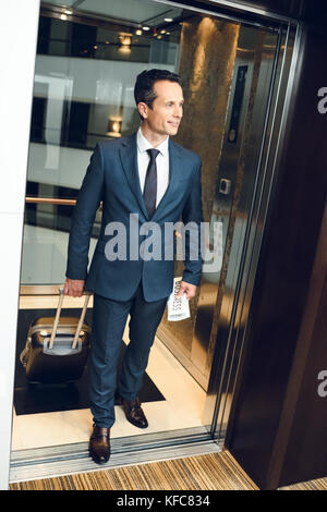 businessman walking out of elevator Stock Photo