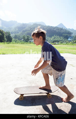 FRENCH POLYNESIA, Moorea. Local kids skateboarding and biking. Stock Photo