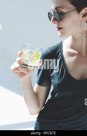 Young beautiful girl drinking glass of healthy orange juice over ...