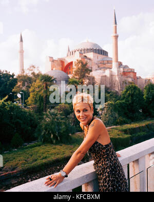 TURKEY, Istanbul, smiling lady looking away with the Aya Sofya mosque in the background Stock Photo