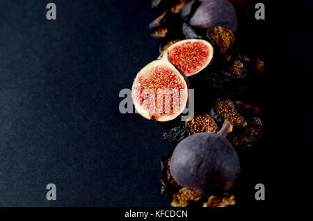 Close-up Picture of Fresh and dried Deep Blue Figs on a Dark Background. Stock Photo
