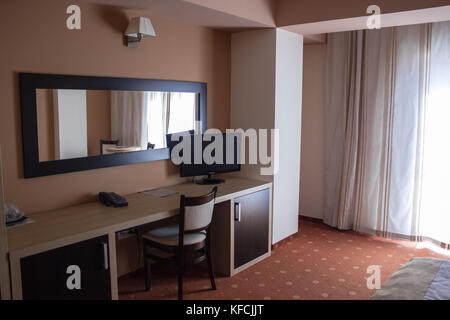 room in the hotel with black telephone and TV and wardrobe desk Stock Photo