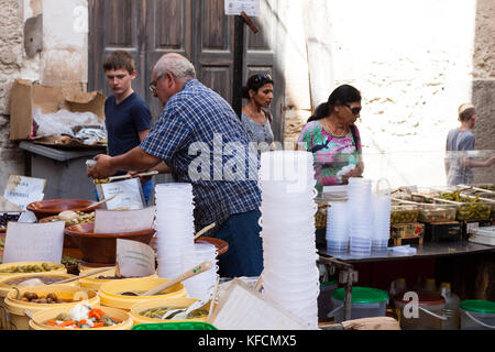 A senior man selling pickled olives at Sineu market, Mallorca, Spain Stock Photo