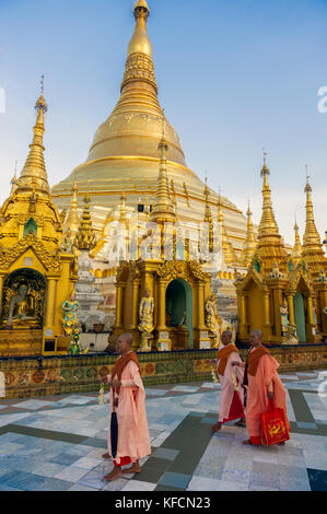 Myanmar (formerly Burma). Yangon. (Rangoon). Nuns walking in front of the great golden stupa at Shwedagon Pagoda Stock Photo