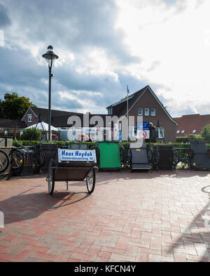 Inselbahnhof, Langeoog.  Deutschland.  Germany.  The official parking area at the railway station especially for bicycle trailers.  This is fairly unique to Langeoog where no personal motorised transport is allowed.  It's a bright day with lots of fast moving clouds. Stock Photo