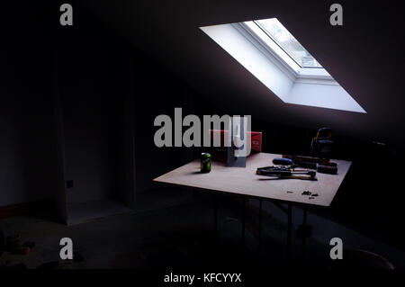 Tools on a table beneath a window in a house under construction. Stock Photo